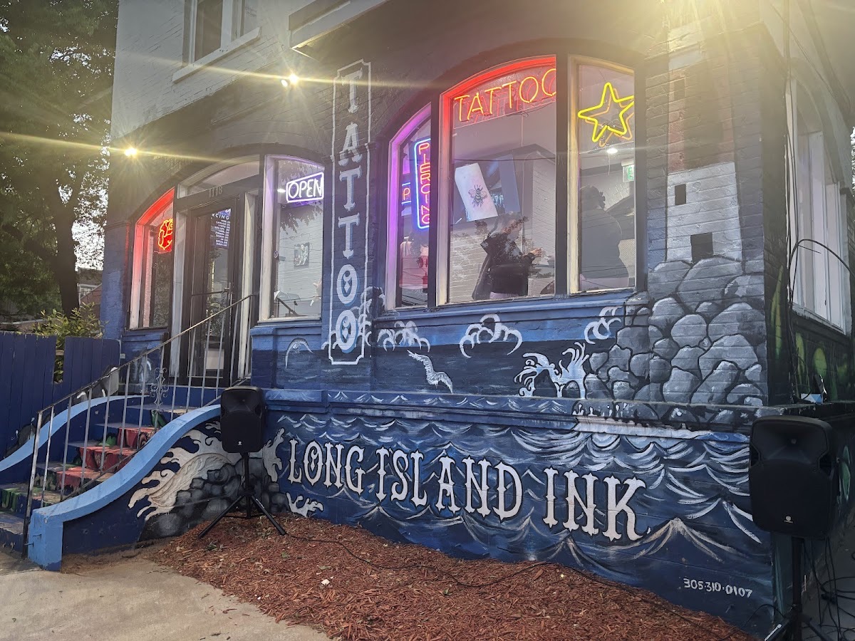 Long Island Ink mural storefront glowing with neon at dusk